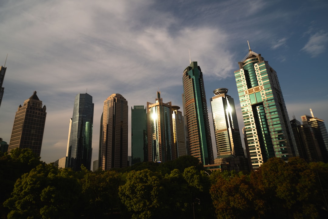 Iron ore pellets on a conveyor belt with a backdrop of a steel mill at sunset, symbolizing market dynamics.