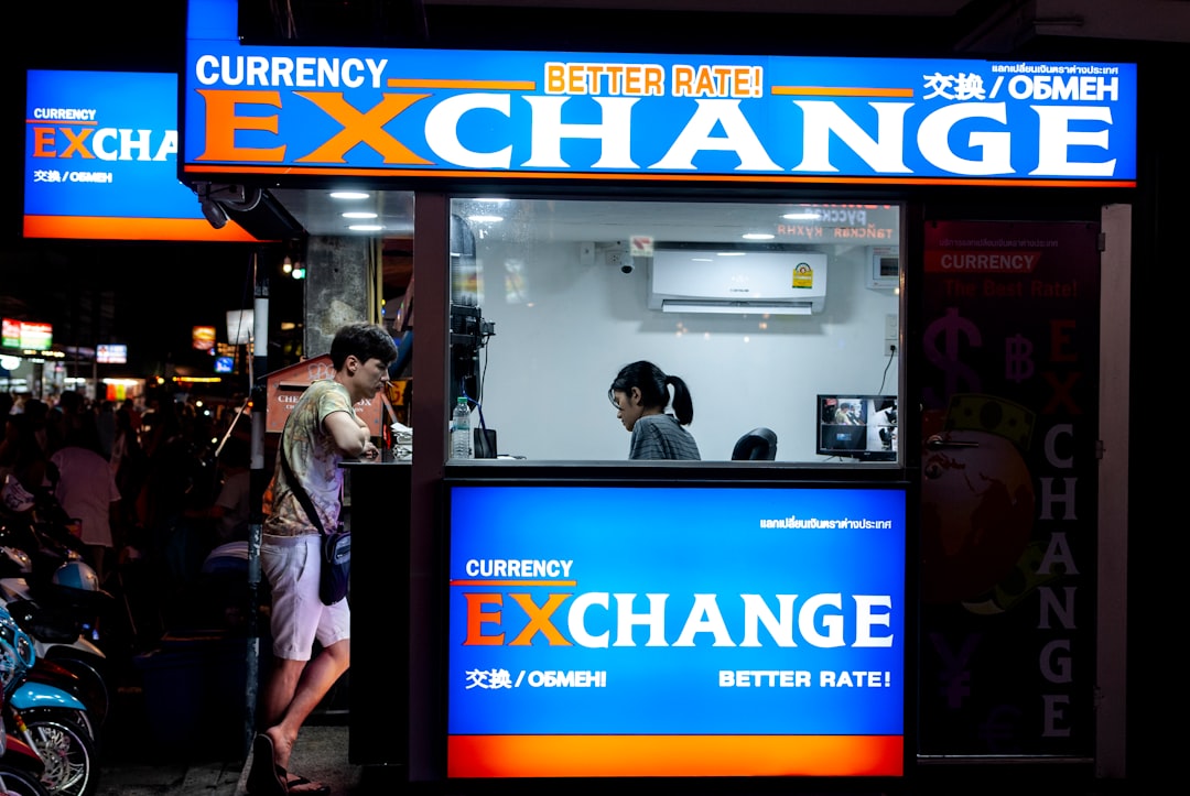 Man near currency exchange, USD/HKD rates, 7.8103 pivot strategy