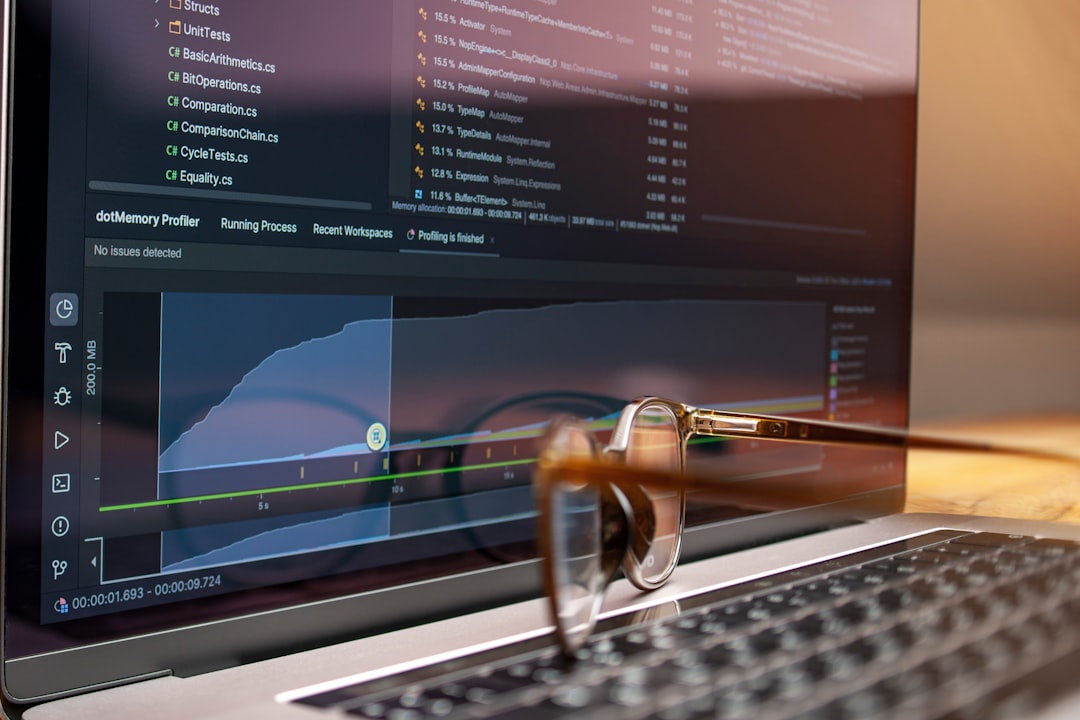 ICP code & graphs on laptop, glasses on keyboard: Internet Computer price analysis.