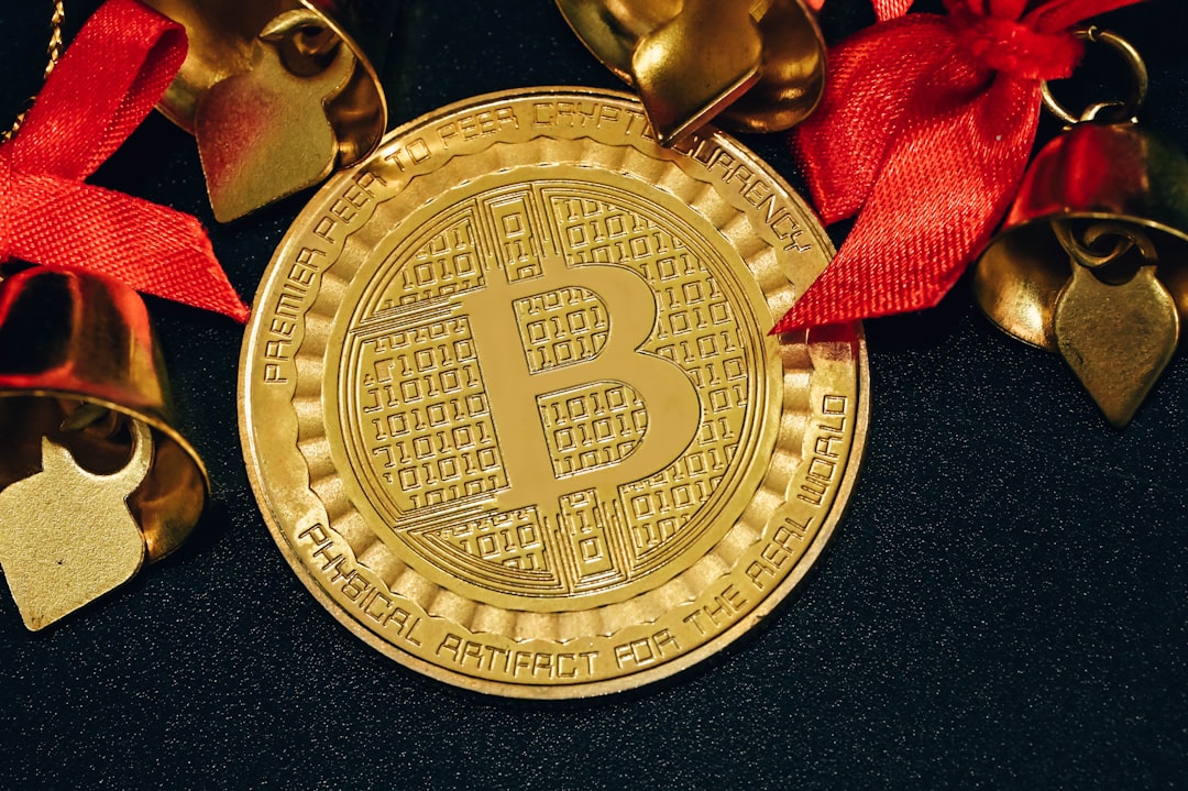 a gold bit coin with a red ribbon around it