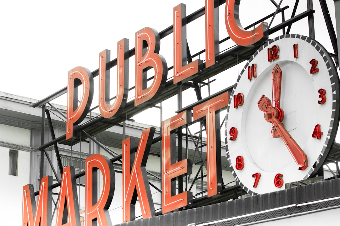 a public market sign with a clock on it