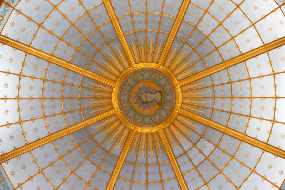 Ornate golden dome interior with radiating sunburst pattern.