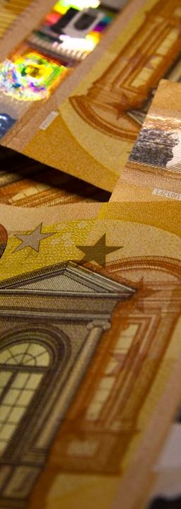 European Union flag reflecting on financial charts, signifying economic analysis and monetary policy.