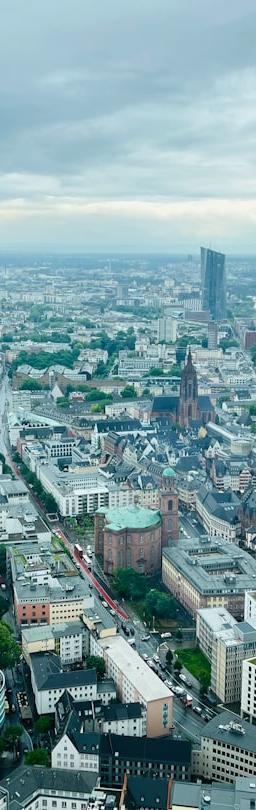 Factory with stockpiled goods and financial charts showing rising costs, symbolizing the cost of resilience in the global economy.