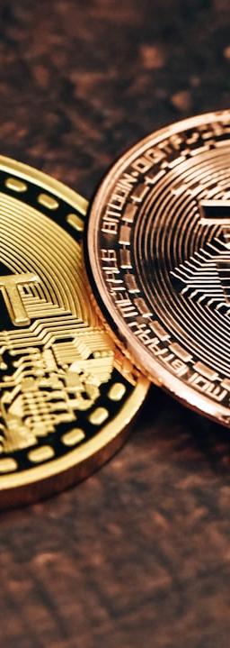 two gold and silver bitcoins sitting on a table