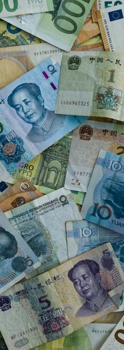 Euro and chinese yuan banknotes scattered together.