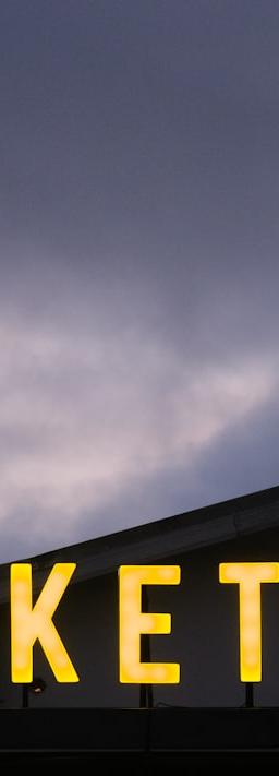 Market sign atop building, symbolizing EV industrial policy shift towards 2026 strategy.