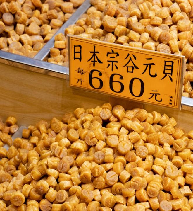 Brown and beige soybeans on a shelf, representing soybean price analysis.