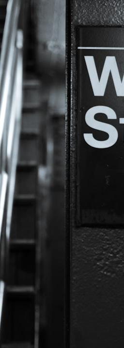 a black and white photo of a wall street sign