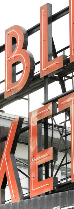 a public market sign with a clock on it