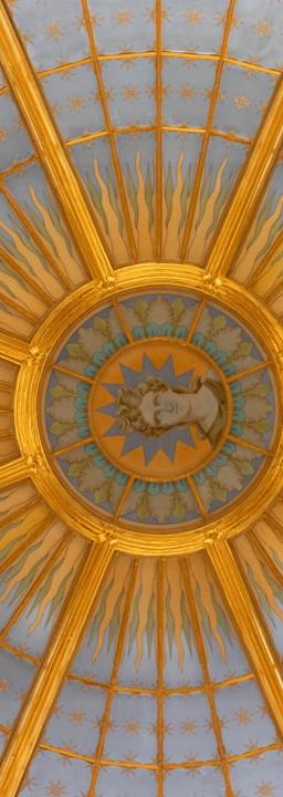 Ornate golden dome interior with radiating sunburst pattern.