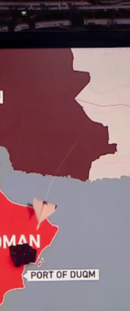 Container ship navigating the narrow Strait of Hormuz with warships in the background, symbolizing geopolitical tension and marine insurance challenges.