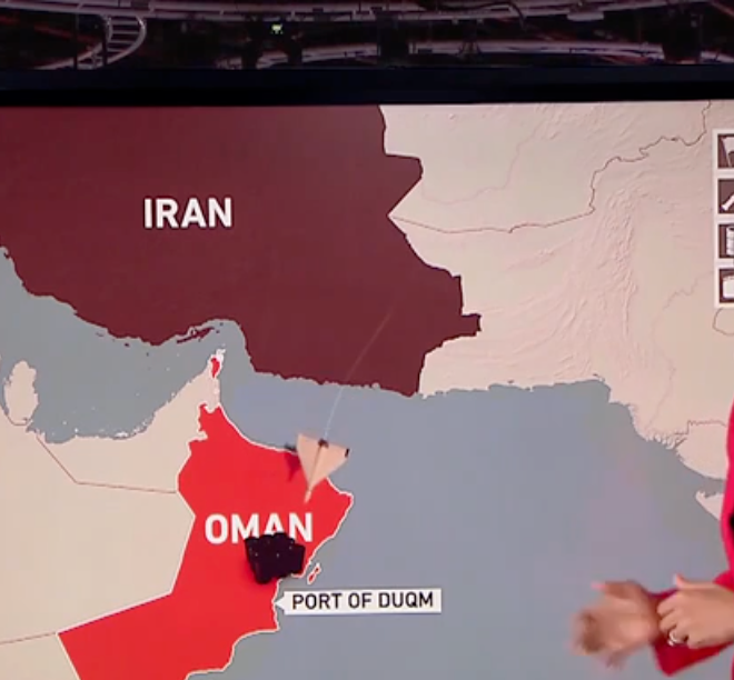 Container ship navigating the narrow Strait of Hormuz with warships in the background, symbolizing geopolitical tension and marine insurance challenges.